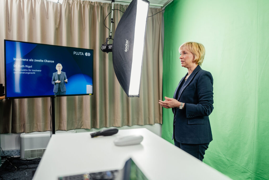 Frau in kleinem Videostudio vor dem Greenscreen während einer Aufnahme